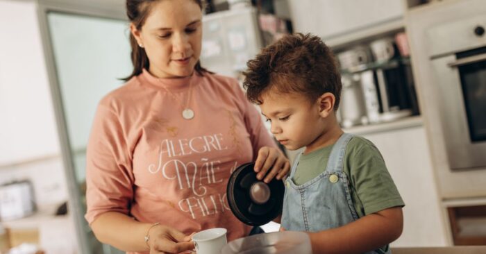 朝の食卓で親子が紅茶を飲みながら笑顔で会話する様子。カフェインレス紅茶を通じて穏やかな時間を共有するイメージ。