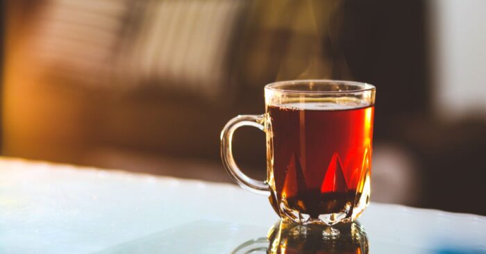 紅茶の湯気が立ちのぼり、心を落ち着かせるような温かい雰囲気のティーカップ