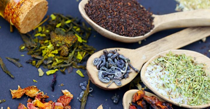 夜の照明の中でルイボスやカモミールなどハーブティーをブレンドする様子