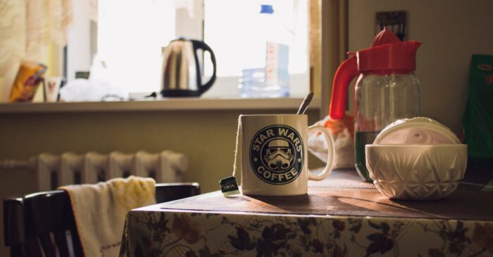 朝日が差し込むダイニングで家族が紅茶を飲みながら穏やかに過ごしている様子。整う朝の空気と家族の笑顔を描いたイメージ。