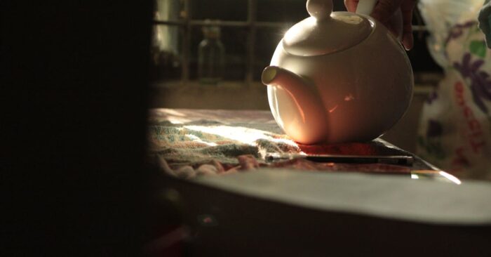 朝日が差し込むダイニングで家族が紅茶を飲みながら穏やかに過ごしている様子。整う朝の空気と家族の笑顔を描いたイメージ。