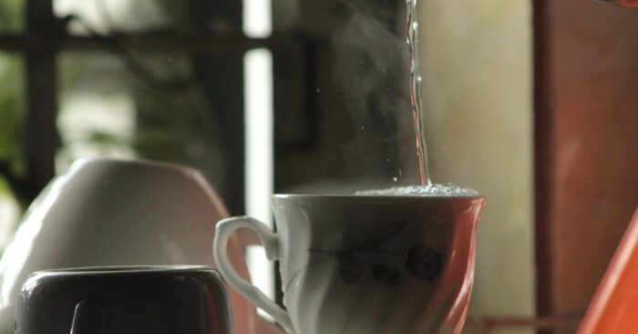 カップから立ちのぼる紅茶の香りをゆっくり感じる女性の手元