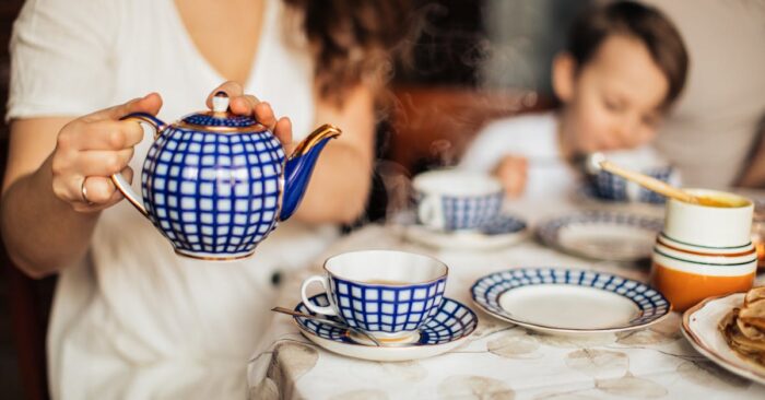 朝日が差し込むダイニングで家族が紅茶を飲みながら穏やかに過ごしている様子。整う朝の空気と家族の笑顔を描いたイメージ。