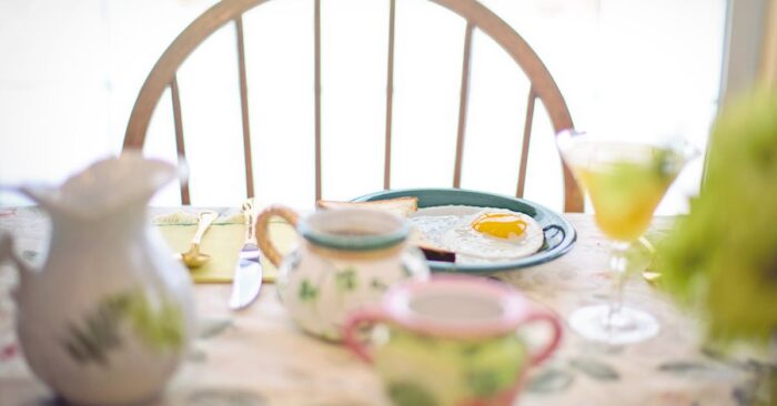朝日が差し込むダイニングで家族が紅茶を飲みながら穏やかに過ごしている様子。整う朝の空気と家族の笑顔を描いたイメージ。