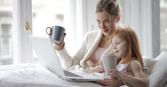 カフェインレス紅茶を並べて夜のティータイムを楽しむママ。カップやティーバッグが並び、柔らかな照明の中で穏やかに過ごす様子。
