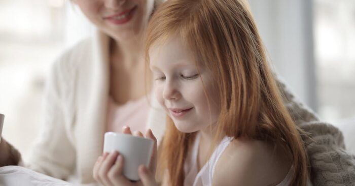 子どもが寝た後に静かな部屋で紅茶を飲みながらほっと一息つくママの様子