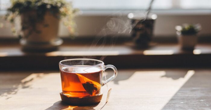朝の食卓で親子が紅茶を飲みながら穏やかに過ごす様子。子どもと一緒にティータイムを楽しむ家庭の風景を表現した画像。