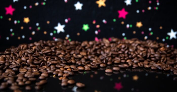 カフェインレス紅茶を並べて夜のティータイムを楽しむママ。カップやティーバッグが並び、柔らかな照明の中で穏やかに過ごす様子。