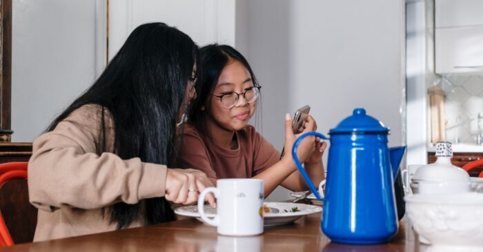 朝の食卓で親子が紅茶を飲みながら穏やかに過ごす様子。子どもと一緒にティータイムを楽しむ家庭の風景を表現した画像。