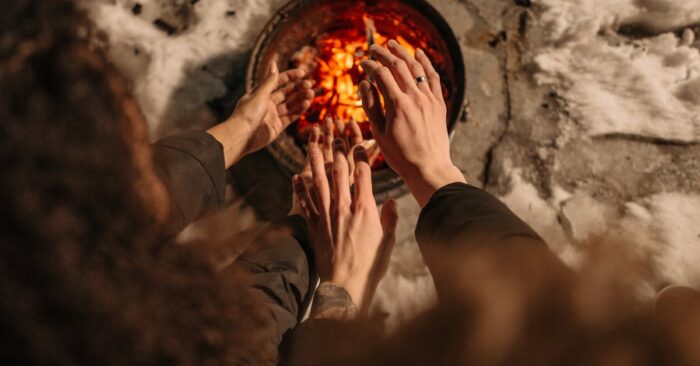 夜のリラックスタイムに紅茶を飲みながら微笑むママ。照明を落とした部屋で温かな光に包まれた穏やかな雰囲気。