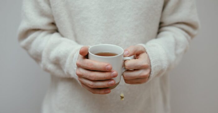 シンプルな白いカップにティーバッグ紅茶を注ぐ瞬間。やわらかな光が差し込むキッチンの雰囲気。