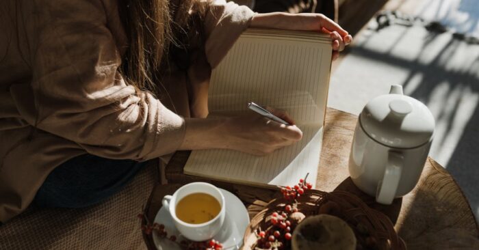 シンプルな白いカップにティーバッグ紅茶を注ぐ瞬間。やわらかな光が差し込むキッチンの雰囲気。