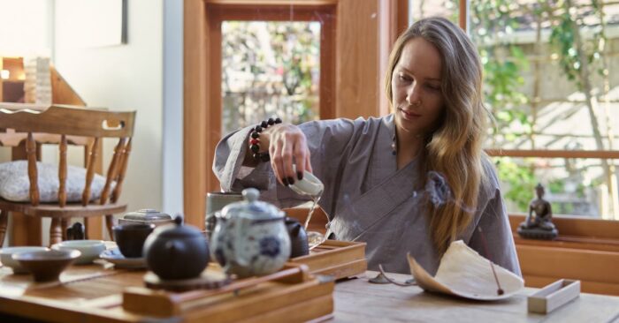 紅茶の湯気を見つめながら深呼吸する女性。穏やかな表情で心を整えている様子。