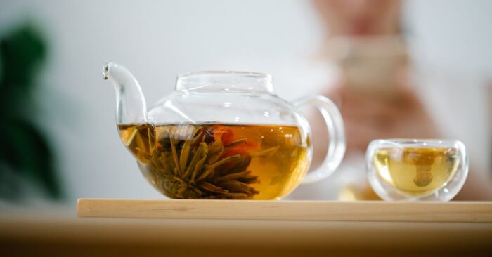 夜のリラックスタイムに紅茶を飲みながら微笑むママ。照明を落とした部屋で温かな光に包まれた穏やかな雰囲気。